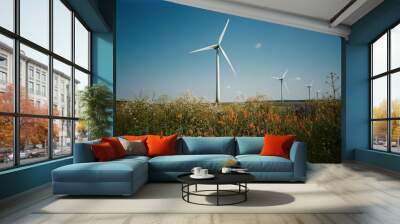 Wind turbines in blooming field under clear sky for sustainable energy concept Wall mural