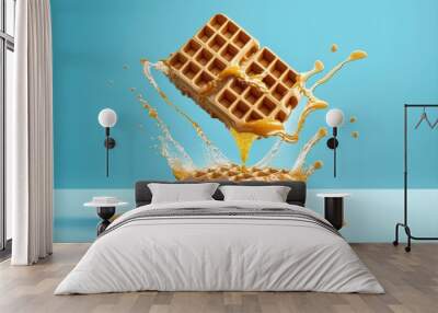 Flying waffles and butter getting dripped with maple syrup over a light blue background. AI generated Wall mural