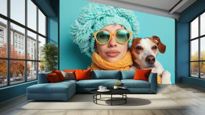 Pet owner and dog in matching sweaters against a bright blue background Wall mural