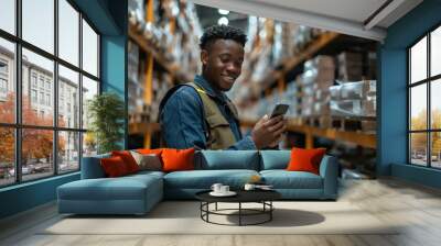 Smiling warehouse worker using smartphone Wall mural