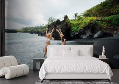 Cheerful girls posing on black beach, Maui, Hawaii Wall mural