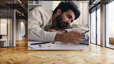 Lazy weary sleepy male manager tired exhausted Arabian Indian businessman employee working computer boring remote job man fall sleep on desktop napping in office overwork fatigue no energy sleeping Wall mural