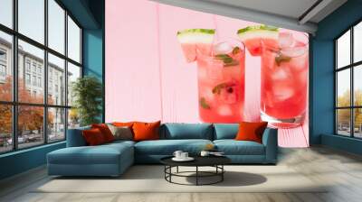 Watermelon lemonade with ice and mint leaves. Homemade lemonade of ripe berry with red and green ripes. Glass of cold watermelon tea. Refreshing summer drink. Cocktail on a wooden background Wall mural