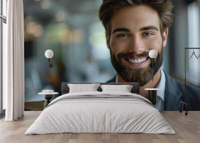 Portrait of beautiful young businessman with a well-groomed beard, smiling and holding a cardboard box in office. Wall mural