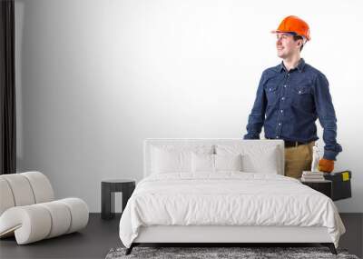 Portrait of repairman (builder) in helmet and with tool box in hands isolated on white background. Copy space Wall mural