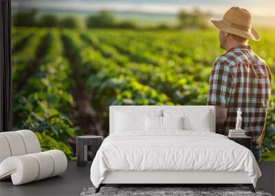 Rural farmer examining soybean field for agriculture concept Wall mural