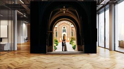 Stylish couple standing in the middle of the corridor tunnel Wall mural