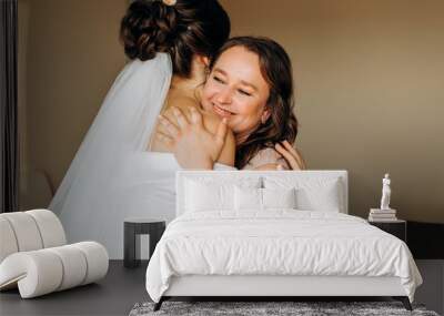 Sweet bride hugs her mom on her wedding day. Wall mural