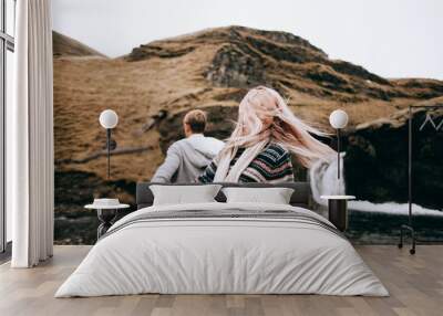 Iceland couple wearing Icelandic sweaters in beautiful nature landscape on Iceland. Woman and man model in typical Icelandic sweater. Wall mural