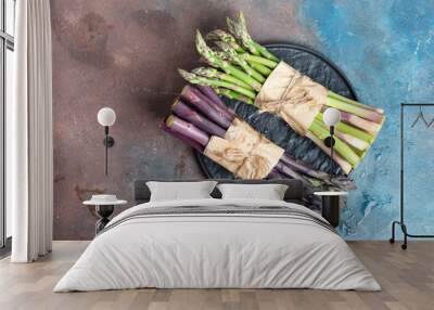 Fresh natural organic two bundles of green and purple asparagus vegetables on a dark stone background. Wall mural