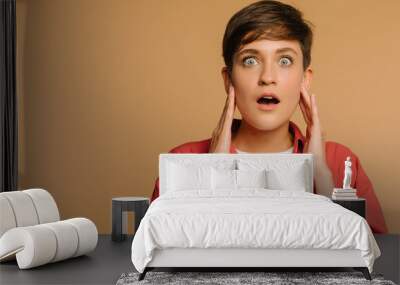  close-up portrait of a surprised girl. beige background in a photo studio Wall mural