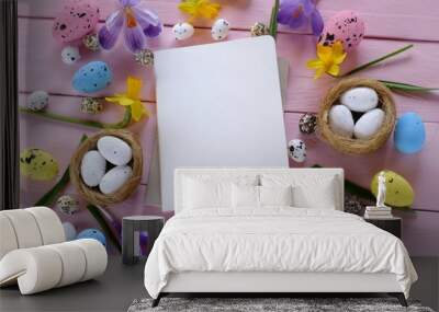 Easter Flat Lay.empty diary and easter decorative eggs in nests, spring flowers crocuses m daffodils on a pink wooden background.top view, copy space.Easter trendy background.Easter holiday Wall mural