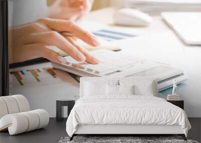 worker using calculator with computer laptop, budget and loan paper in office. Wall mural