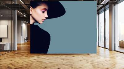 Portrait of beautiful girl in hat in profile, posing in studio Wall mural