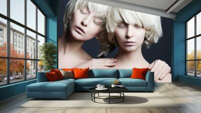 Portrait of two beautiful girls twins with closed eyes in studio Wall mural