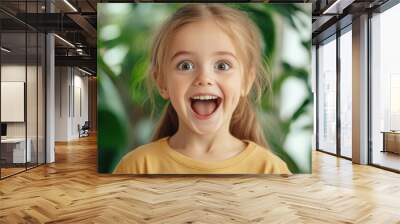 A young girl with wide eyes, showing pure excitement Wall mural