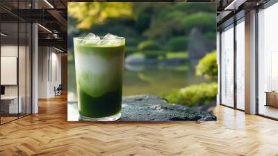 A glass of iced matcha latte with a blurred green background. Wall mural