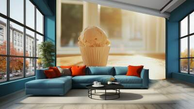 A single scoop of ice cream in a white cup sits on a wooden table in front of a window, sunlight streaming in. Wall mural