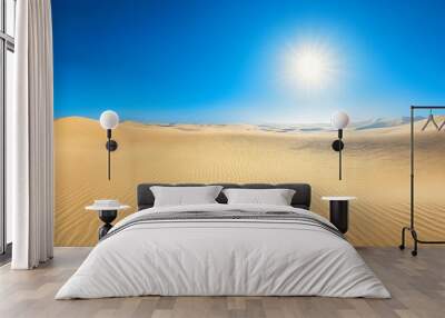 A sunny day in a desert landscape with rippled sand dunes and a clear blue sky. Wall mural