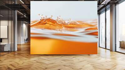 Close-up of an orange liquid with a single drop creating a small wave. Wall mural