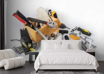 Construction tools lie in a wooden box and next to it on a white background. Wall mural