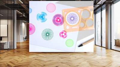 Spirograph ruler on white background. Drawing the spirograph pattern on white paper. drawing the spirograph pattern with spirograph kit. Wall mural