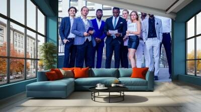 a group of seven successful business people businesslady and her male partners in stylish suits standing and looking proudly outdoors . teamwork and the multiethnic company concept Wall mural