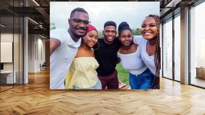 group of five friends female and male taking selfie on camera smartphone and having fun outdoors lifestyle near lake Wall mural