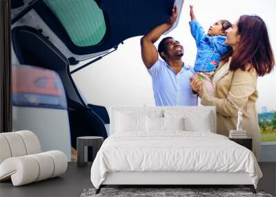 latin hispanic man and beautiful woman with cute daughter ready for trip on car Wall mural