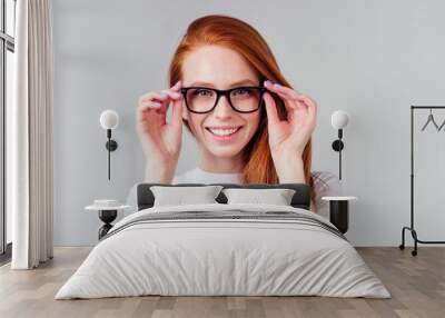 redhaired ginger woman feeling happy ,wearing white cotton t-shirt in gray studio background Wall mural