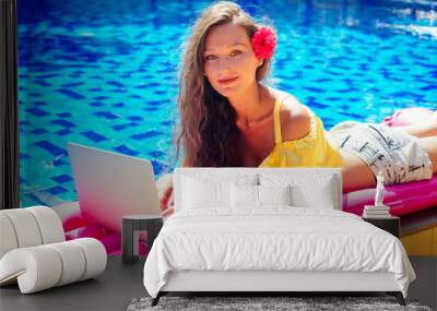 remote work dream job.young woman sitting on inflatable pink mattress in the swimming pool having sunbath and working on laptop.girl eating exotic fruits tropical mango, pineapple and dragon fruit Wall mural