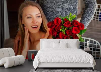 surprised blonde woman and handsome blond man at restaurant.happy couple romantic date, celebrating valentine day male model give red rose to his girl Wall mural