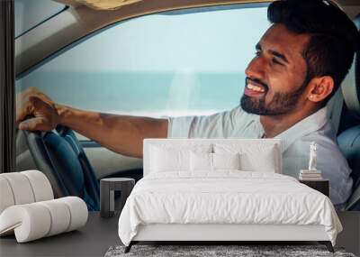 travel vacation happy indian man in white shirt collar buying new car and showing the key, sitting in car on beach sea india octan Goa .a trip to the beach in car Wall mural