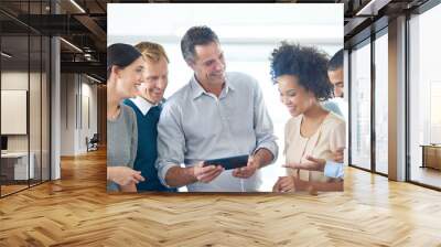 Everything is easier with technology. Shot of a group of colleagues using a digital tablet together. Wall mural