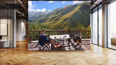 Woman, nature and eating on a balcony for holiday, vacation and travel destination at a countryside hotel or lodge. Person with breakfast, food and thinking of mountains or view on eco friendly patio Wall mural