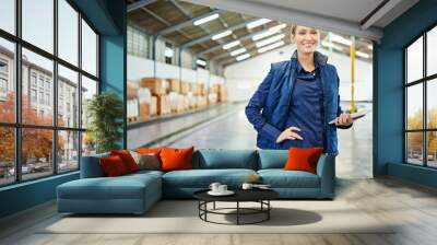 Digital devices have made inventory a breeze. Shot of a young woman working in a warehouse. Wall mural