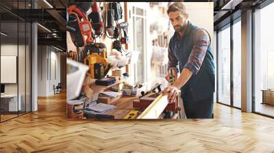 Craftsman at work. Shot of a carpenter making measurements on a plank of wood. Wall mural