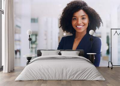 Cropped portrait of an attractive young businesswoman smiling and standing in the office with her arms crossed during the day Wall mural