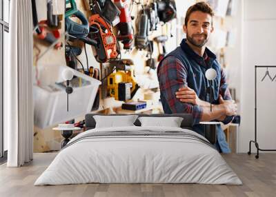 Lets fix it. Portrait of a handsome young handyman standing in front of his work tools. Wall mural