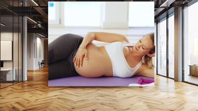 Mommy cant wait to meet you. Cropped shot of an attractive young pregnant woman lying on her side on a yoga mat. Wall mural