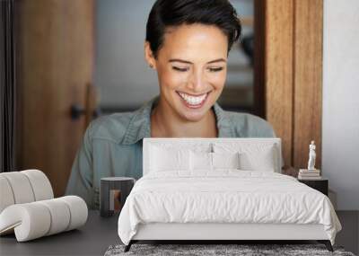 Right on time. Shot of a smiling young woman standing at her front door receiving a package from a courier. Wall mural