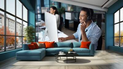 understanding starts with listening. shot of a young man using a headset and computer in a modern of Wall mural