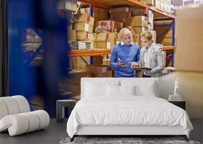 We always double check orders. a man and woman inspecting inventory in a large distribution warehouse. Wall mural