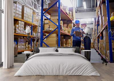 We know where every order is in this warehouse. Shot of a man and woman inspecting inventory in a large distribution warehouse. Wall mural