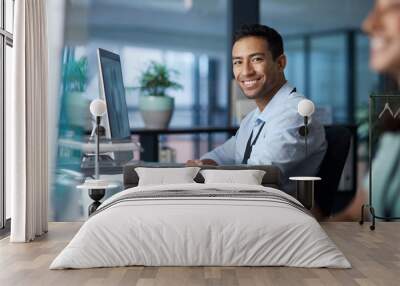 your quality of work determines your worth. shot of a young businessman using a computer in a modern Wall mural