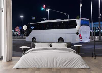 Tourist bus moves at night along street Wall mural