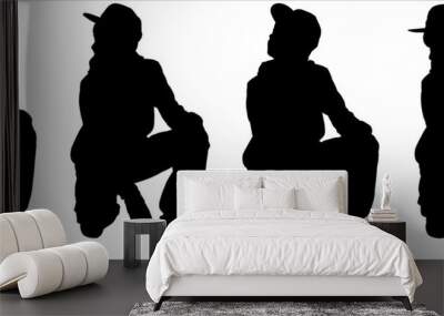 A teenager in a fashionable cap. The boy squatted down. Fashion stylish teenage boys. Children's fashion. Model. Front view, full face, half-side, side. Four black teen silhouettes are isolated. Wall mural