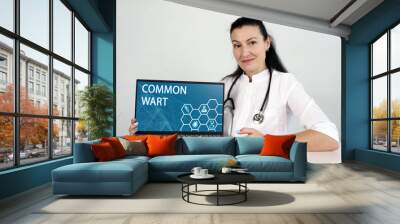  COMMON WART text in list. Neurologist looking for something at laptop. Wall mural