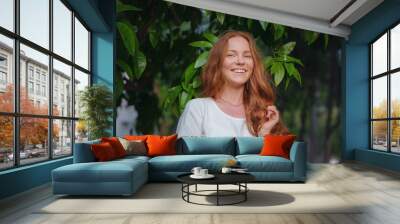 Beauty Woman Face With Healthy Skin And Green Plant at sunset time outdoor. Healthy lifestyle, beauty, natural concept. Melancholic beautiful portrait Wall mural