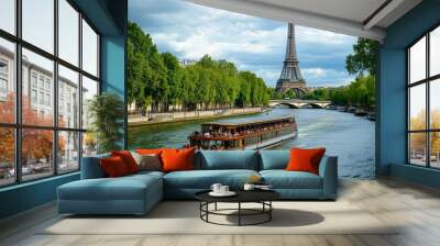 Tourist boat cruising on the seine river with the eiffel tower towering over paris, europe Wall mural